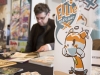 WINDSOR, Ont. (14/02/16) – A cardboard sign for Ellie on Planet X is pictured sitting on a table in front of its creator, James Anderson, at the 2016 Comic Book Syndicon at the St. Clair College Centre for the Arts in Windsor on Sunday, Feb. 14, 2016. Photo by Justin Prince